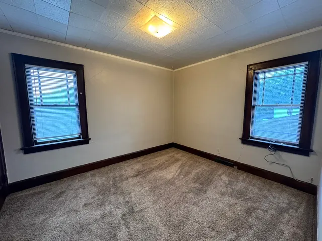 an empty room with windows and closet