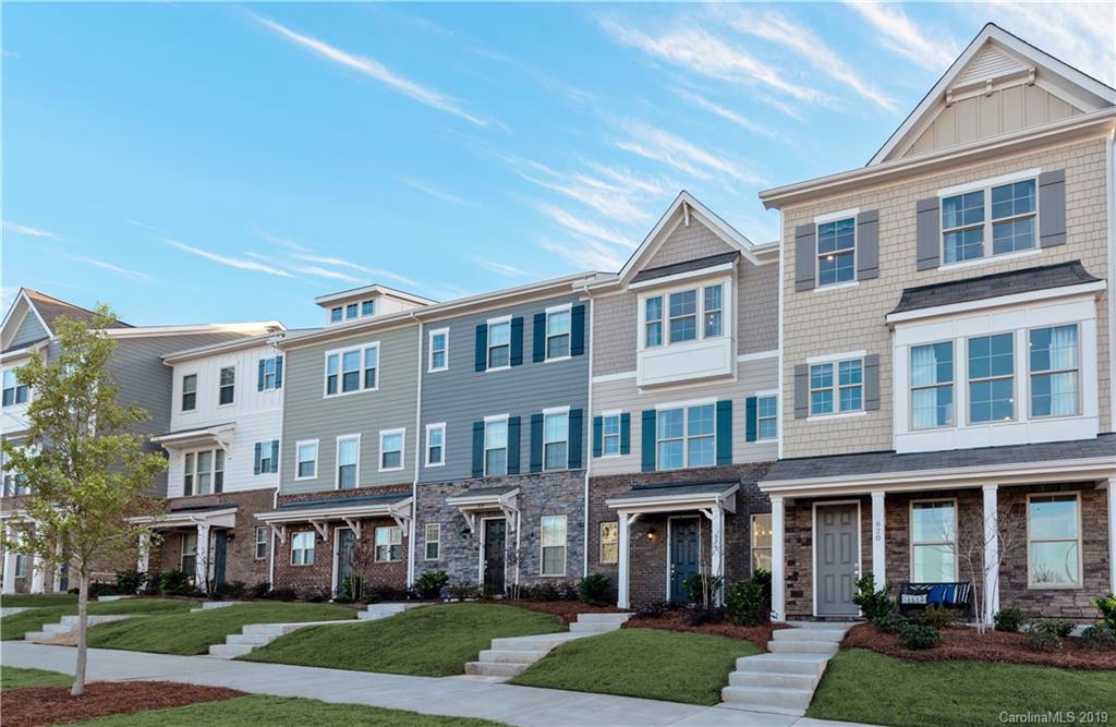 a front view of a building with yard and parking spaces