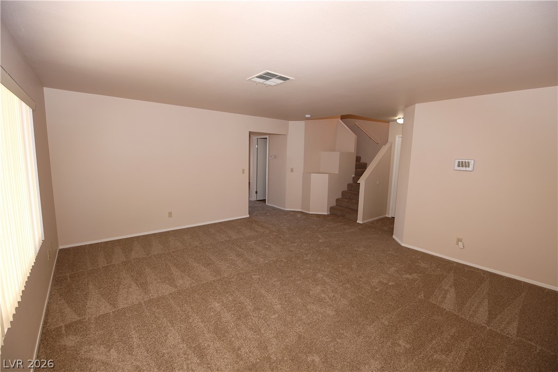 8220 Maplestar Road Las Vegas, NV 89128 - Photo 4 of 29 A spacious room presents a clean canvas with light walls and neutral carpet, ready for personalization.