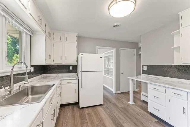 a kitchen with a refrigerator sink and cabinets