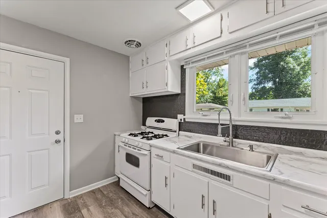 a kitchen with stainless steel appliances granite countertop a sink stove and a refrigerator