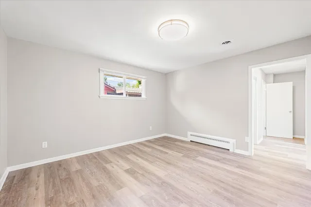 a view of empty room with wooden floor