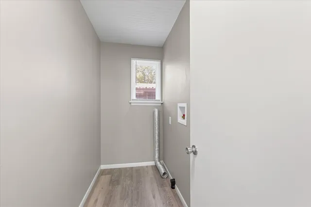 a view of a hallway with wooden floor and closet