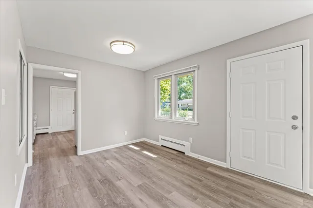 an empty room with wooden floor and windows