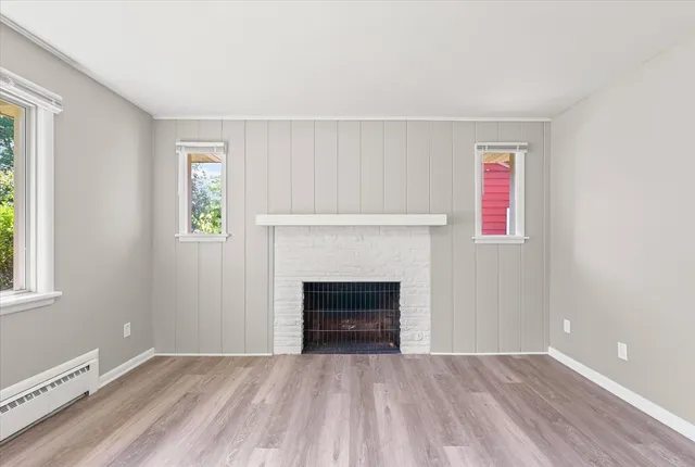 an empty room with windows and fireplace