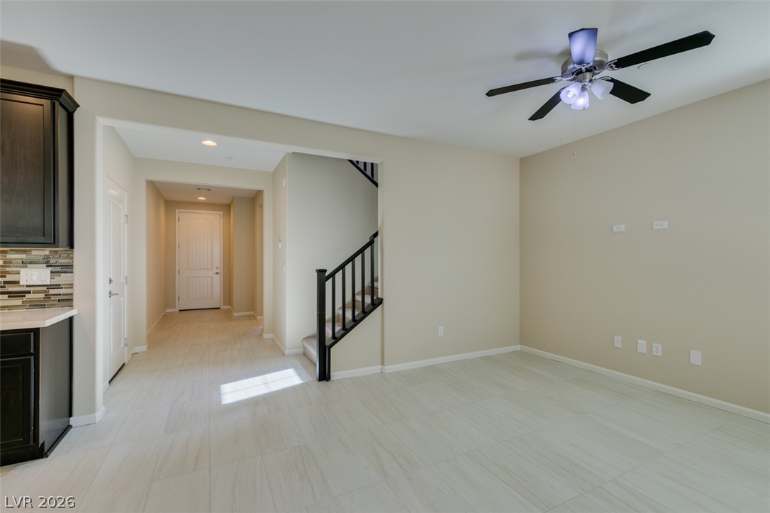 2549 Sable Ridge Street Henderson, NV 89044 - Photo 14 of 48 A well-lit interior offers a clean aesthetic with a stylish ceiling fan and a visible staircase.