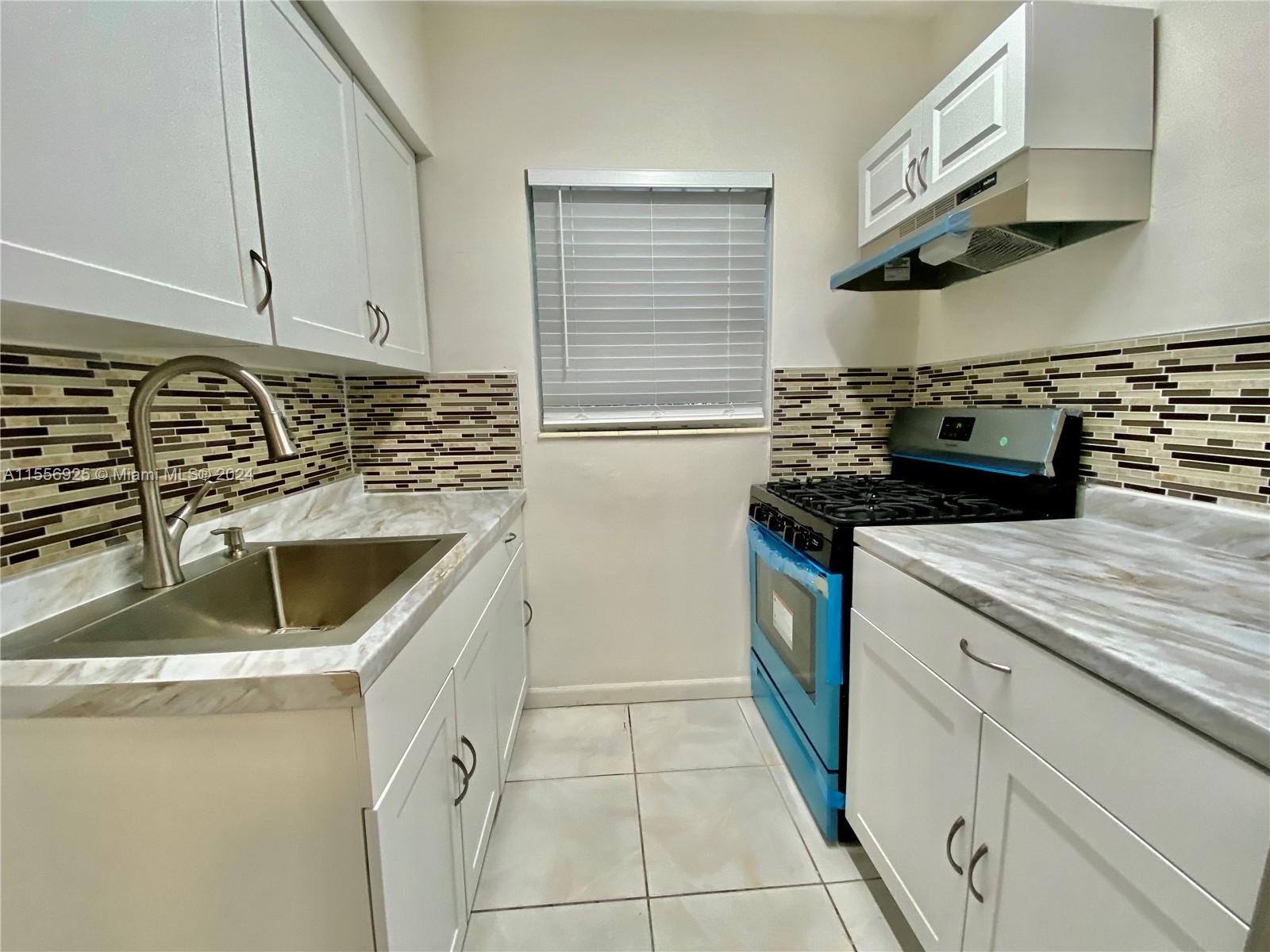 a kitchen with a sink and a stove top oven
