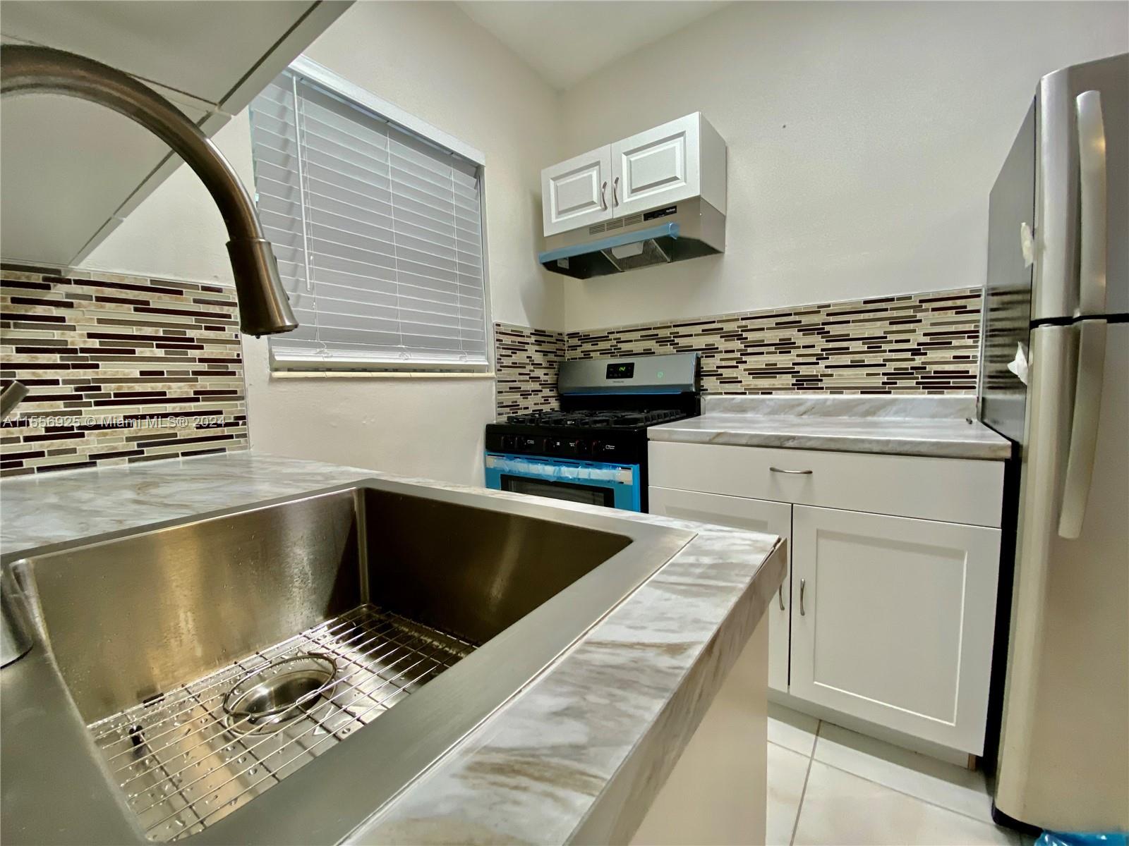 7625 Harding Avenue, Unit 1 Miami Beach, FL 33141 - Photo 2 of 11 a kitchen with a stove and a microwave