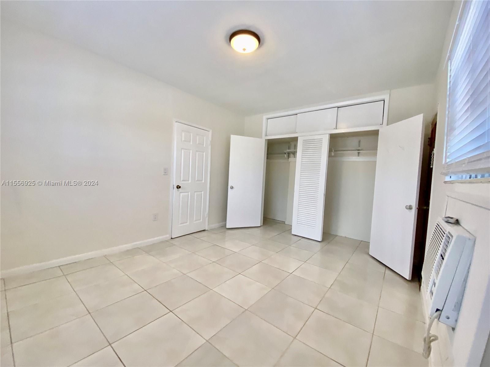 7625 Harding Avenue, Unit 1 Miami Beach, FL 33141 - Photo 8 of 11 a view of an empty room with a window