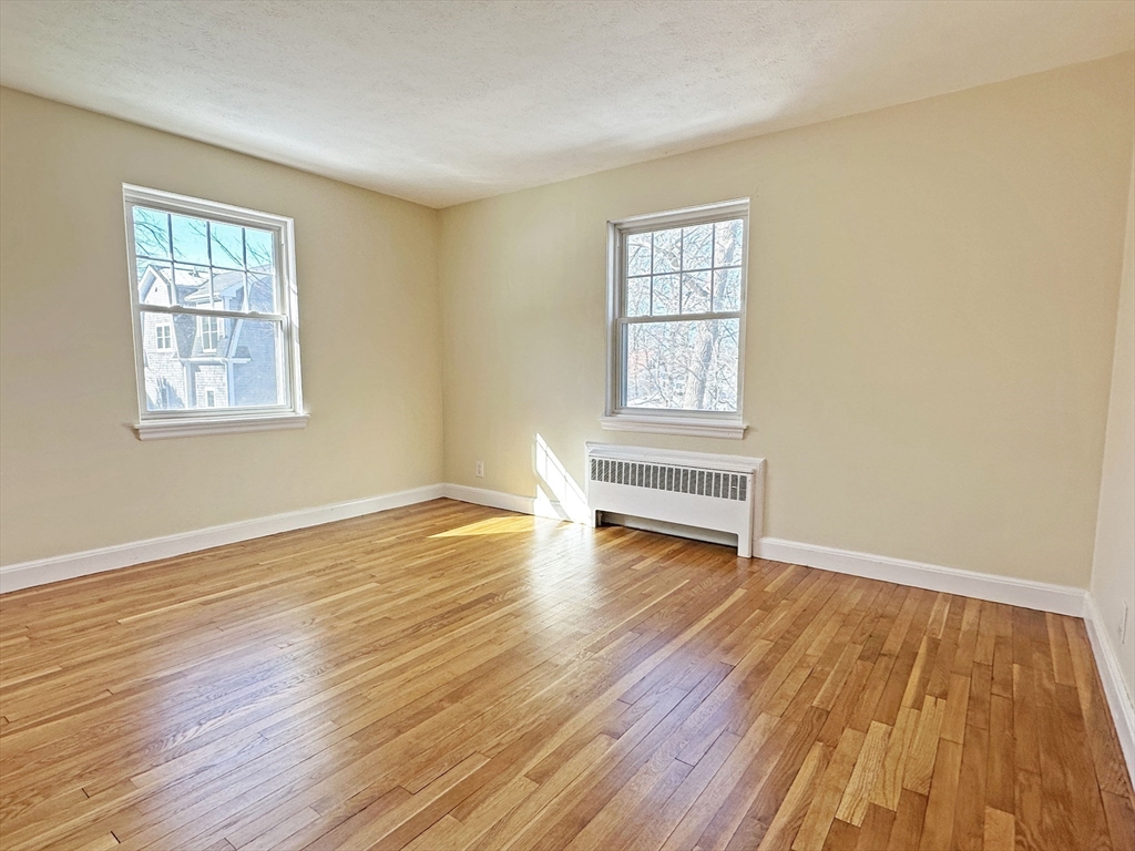 99 Withington Road Newton, MA 02460 - Photo 14 of 33 a view of an empty room with wooden floor and a window