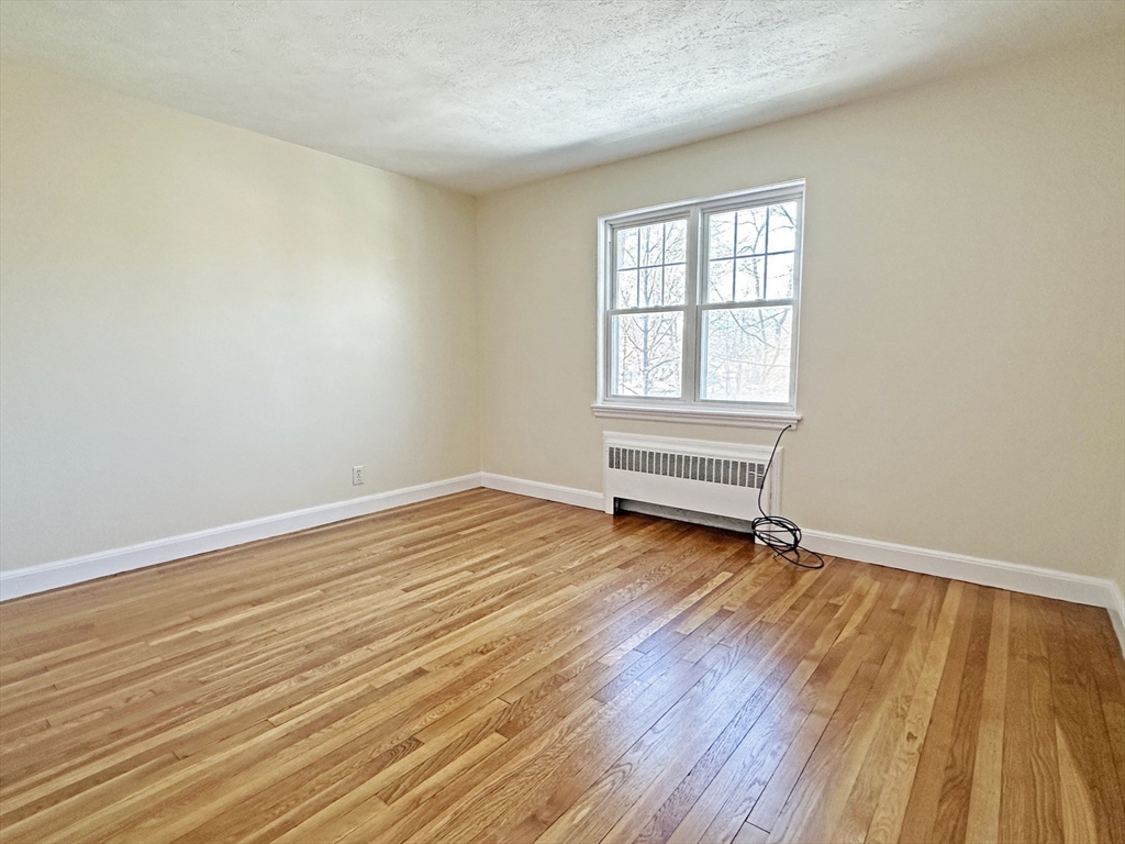 99 Withington Road Newton, MA 02460 - Photo 15 of 33 an empty room with wooden floor and windows