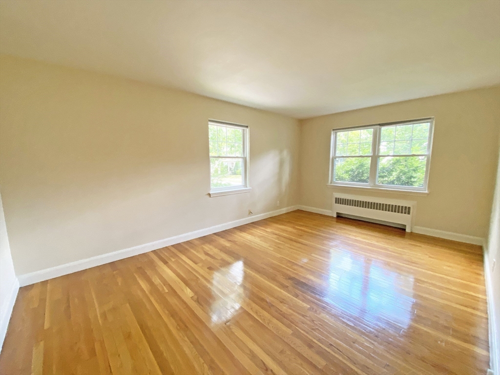 99 Withington Road Newton, MA 02460 - Photo 21 of 33 a view of an empty room with wooden floor and a window