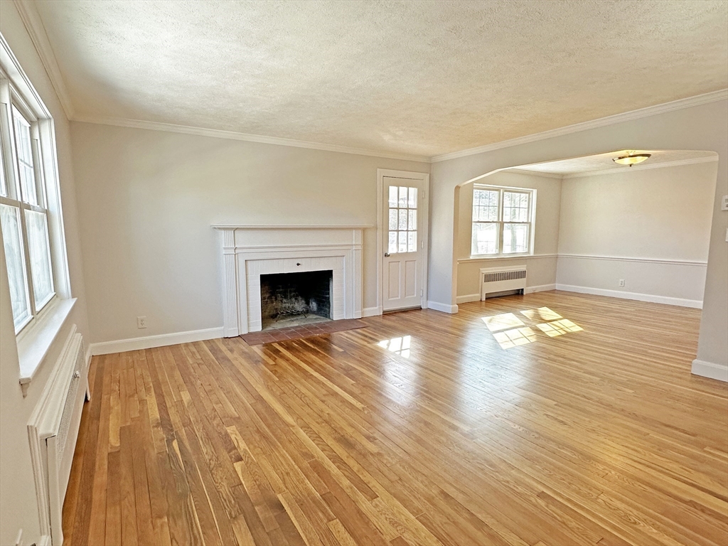 99 Withington Road Newton, MA 02460 - Photo 4 of 33 a view of empty room with wooden floor and fireplace