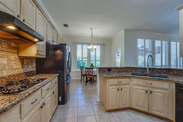 a kitchen with granite countertop a sink stove and cabinets