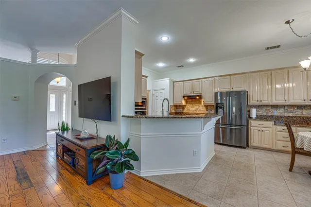 a kitchen with stainless steel appliances wooden floor and a refrigerator