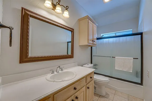 a bathroom with a sink vanity granite and toilet