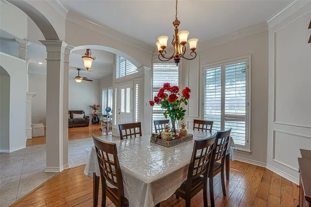 a dining room filled chandelier and wooden floor