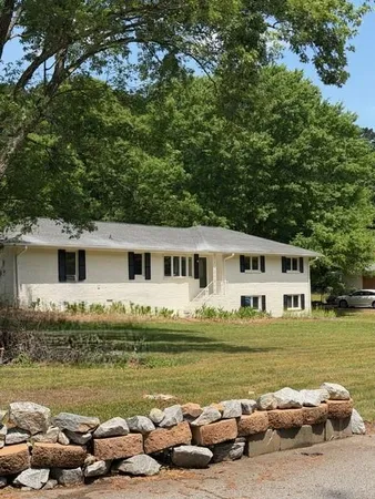 a front view of a house with a garden and swimming pool