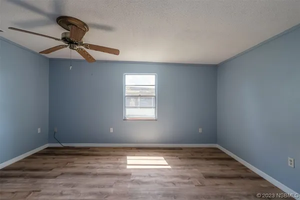 a view of a room with a ceiling fan and wooden floor