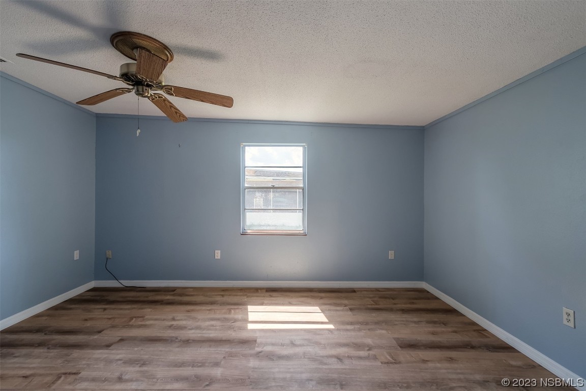 209 Pine Avenue Edgewater, FL 32141 - Photo 18 of 34 a view of empty room with wooden floor and ceiling fan
