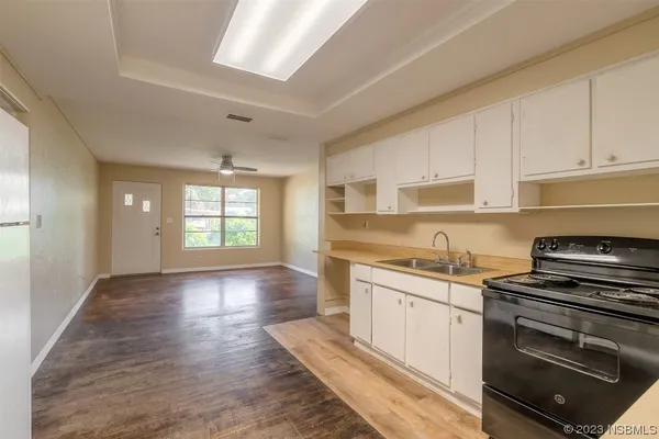 a view of an empty room with window and wooden floor
