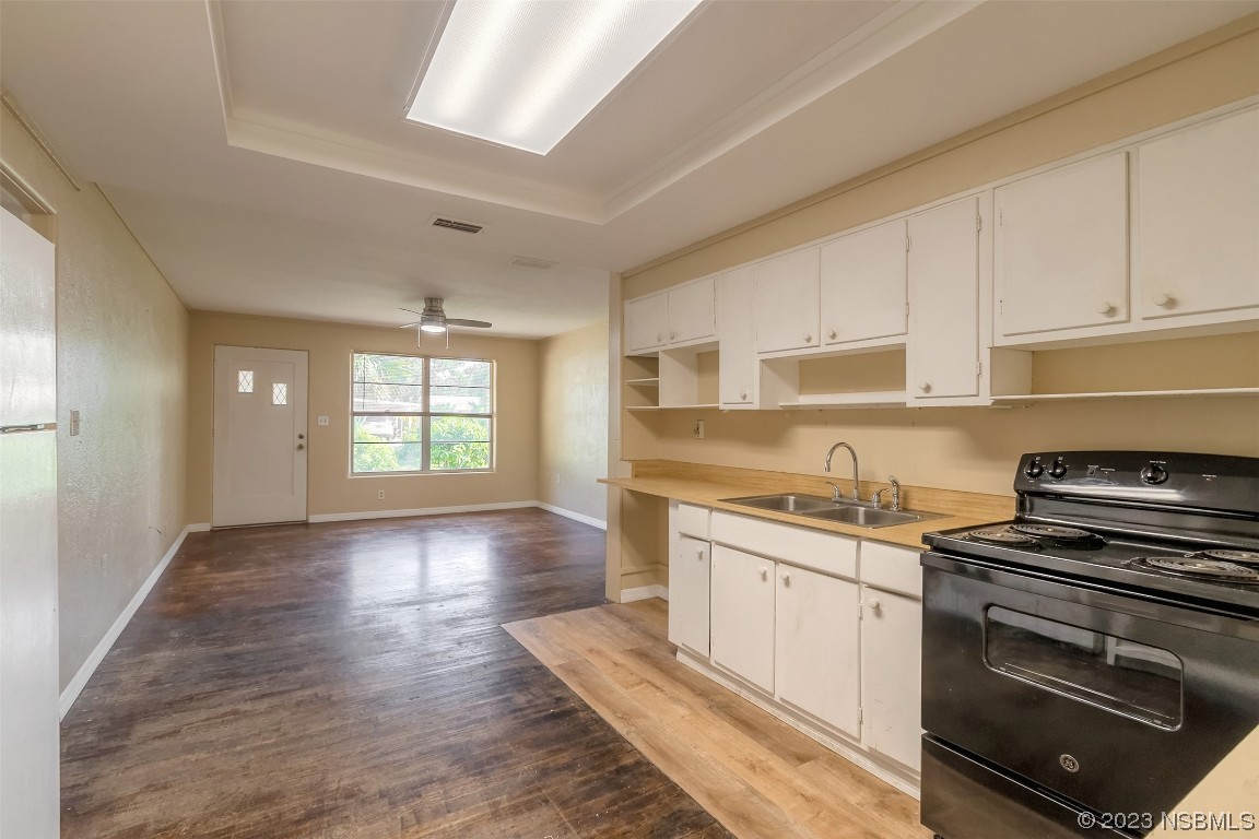 209 Pine Avenue Edgewater, FL 32141 - Photo 8 of 34 a kitchen with granite countertop a stove a sink and white cabinets