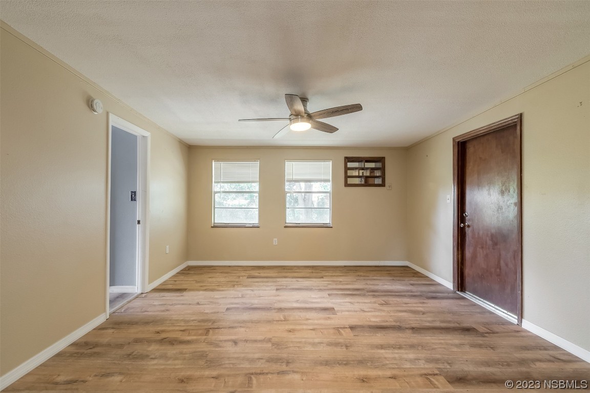209 Pine Avenue Edgewater, FL 32141 - Photo 9 of 34 a view of an empty room with window and wooden floor