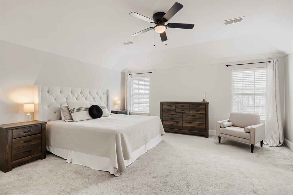603 Ash Street Pilot Point, TX 76258 - Photo 16 of 28 Vaulted ceiling with a ceiling fan, light-toned carpeting, and two windows with blinds
