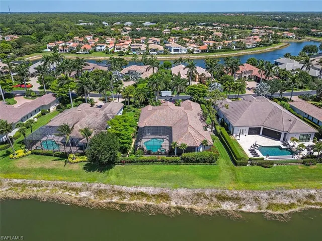 an aerial view of residential houses with outdoor space and lake view