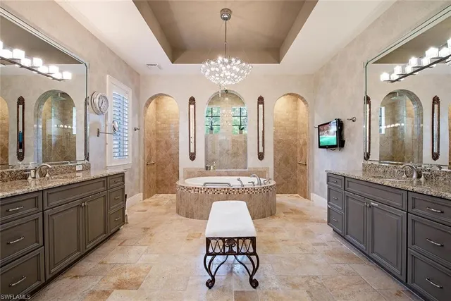 a spacious bathroom with a double vanity sink a mirror a bathtub and a shower