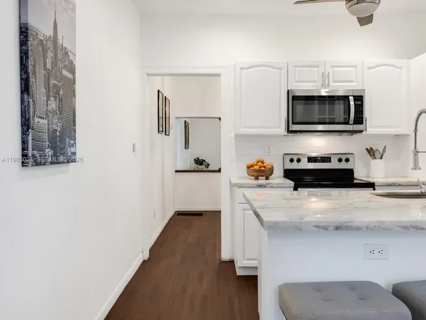 a bedroom with a bed a tv and wooden floor
