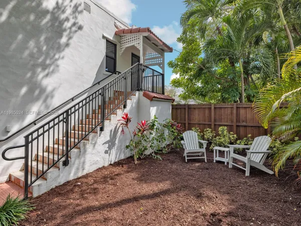 a view of a chairs and tables in the back yard of the house