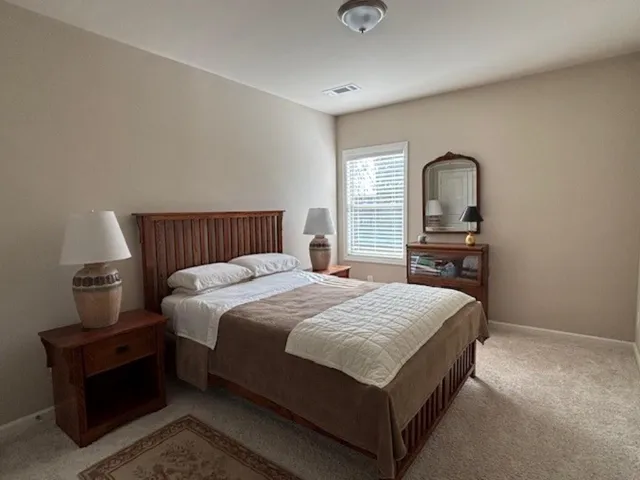 a bathroom with a granite countertop double vanity sink and a mirror