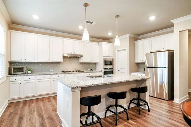 a kitchen with granite countertop white cabinets and a stove