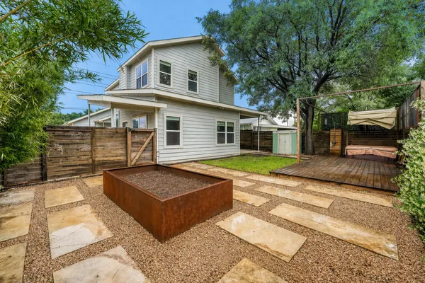 a view of house with yard outdoor seating and covered with trees