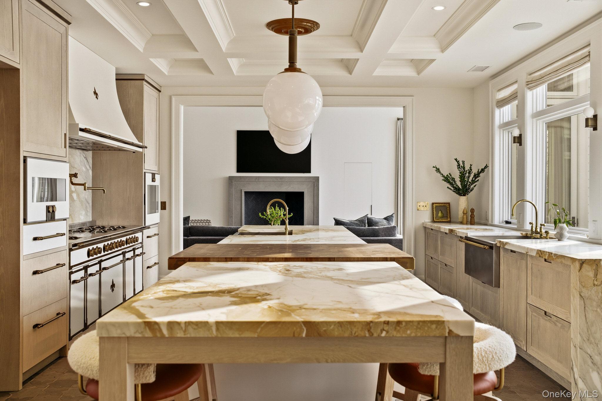 217 Hommocks Road Larchmont, NY 10538 - Photo 4 of 49 a large white kitchen with a stove a sink dishwasher and a fireplace with wooden floor