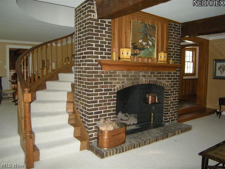 6945 Gates Road Gates Mills, OH 44040 - Photo 4 of 25 Beautiful brick fireplace and sweeping circular staircase can be viewed from the living room and dining room.