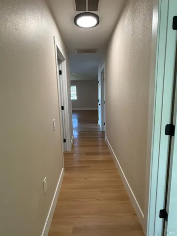 a view of a hallway with wooden floor