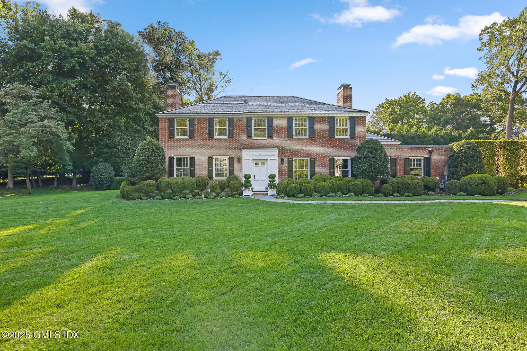 a front view of a house with a garden