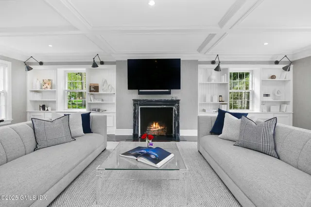 a living room with furniture a flat screen tv and a fireplace