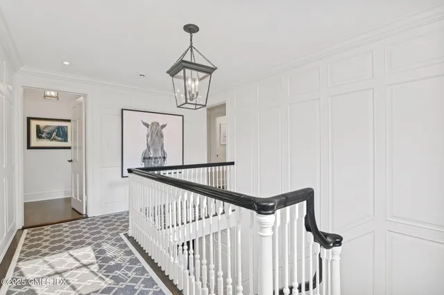 a view of a hallway with wooden floor and staircase