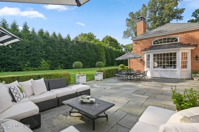 a view of a patio with couches table and chairs and potted plants