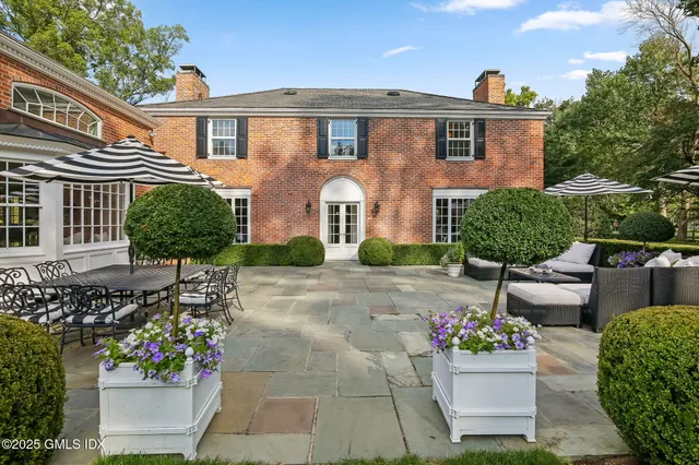 a front view of a house with a yard and potted plants
