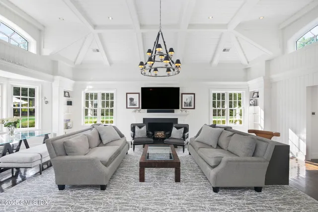 a living room with furniture a flat screen tv and a large window