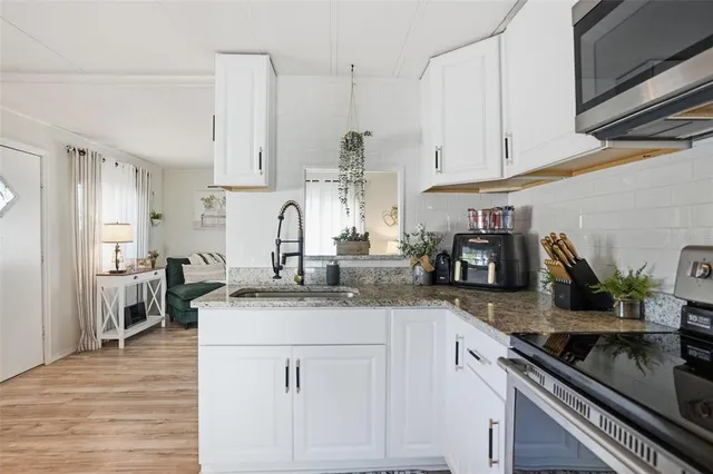 a kitchen with granite countertop a refrigerator stove and sink