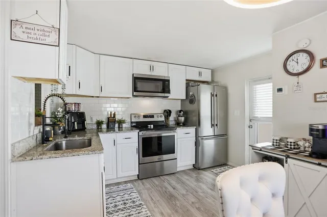 a kitchen with stainless steel appliances granite countertop a sink and a stove