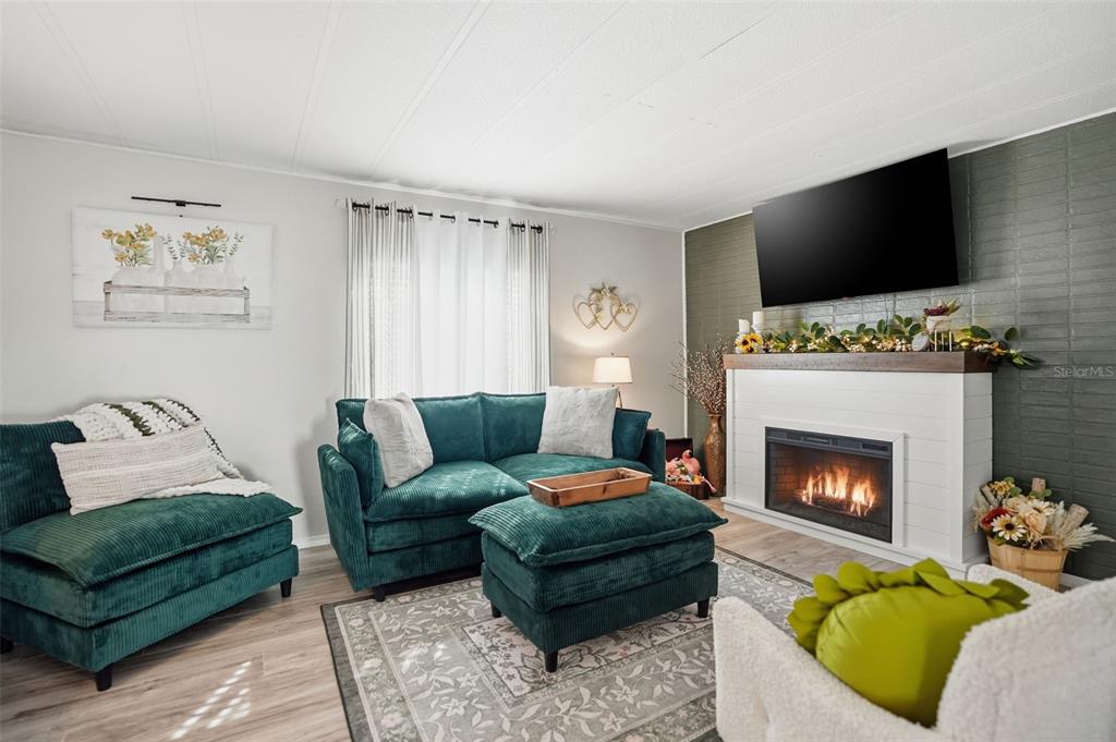 8055 Country Club Drive Brooksville, FL 34613 - Photo 7 of 33 a living room with furniture a flat screen tv and a fireplace