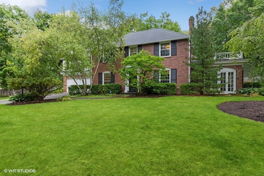 210 Franklin Road Glencoe, IL 60022 - Photo 2 of 33 a view of a big yard in front of a brick house with plants and large trees