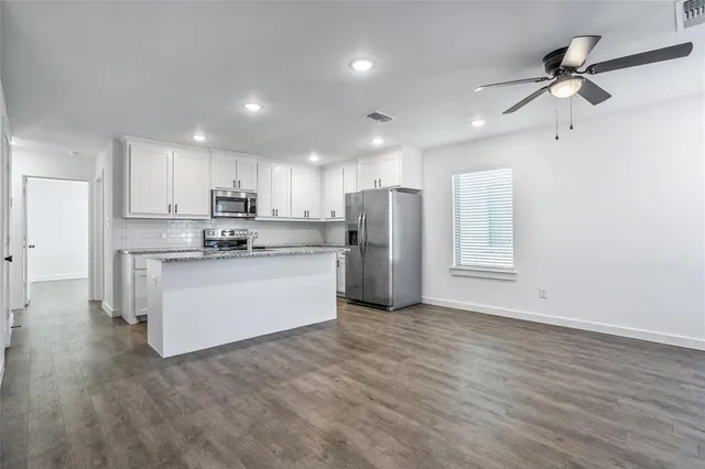 a view of kitchen with stainless steel appliances refrigerator stove microwave and cabinets