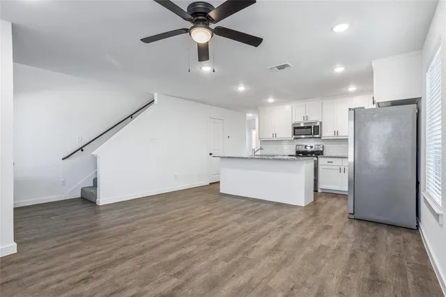 a large kitchen with stainless steel appliances a refrigerator and a stove top oven